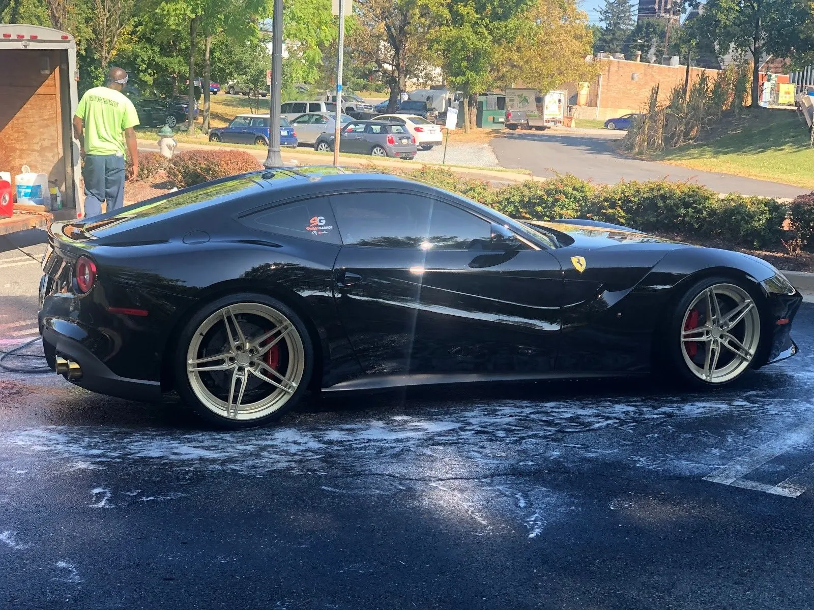 Mobile car detailing in progress: a Melvin's crew member washing a black sports car on site