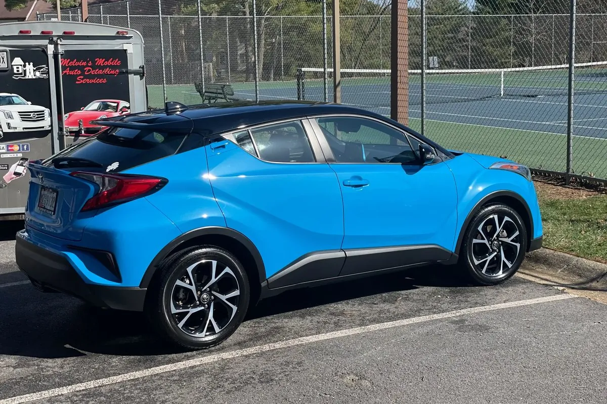 Freshly washed blue Toyota C-HR beside the Melvin's detailing trailer